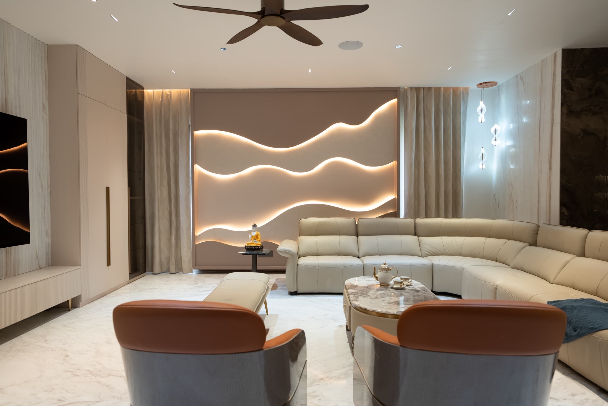 Living room with a backlit wave feature wall and cream sectional, designed by Simplify Home, Hyderabad