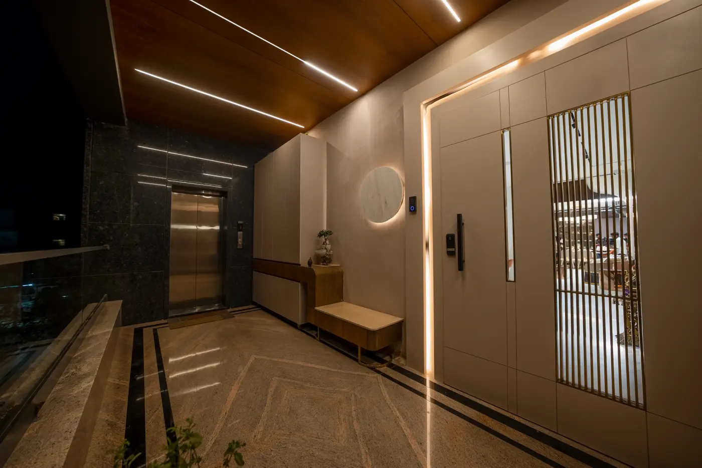 Entrance lobby with aligned wall panels, linear lighting and a wooden ceiling