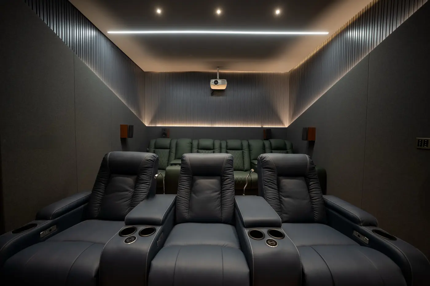 Home theatre with acoustic wall panels, a false ceiling with cove lighting and recessed spotlights