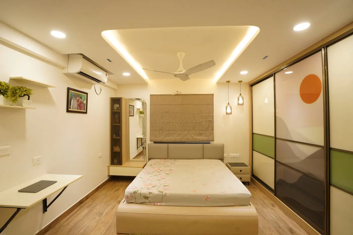 Bedroom with a cove-lit false ceiling, pendant lights beside the bed and a wardrobe wall